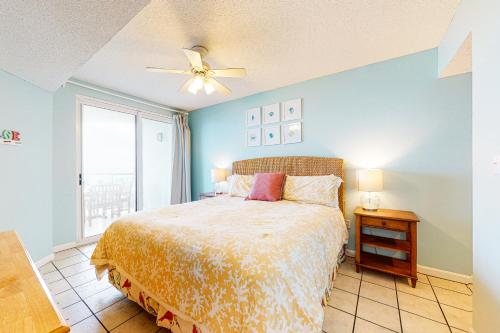 奥兰治比奇Silver Beach 205的一间卧室配有一张床和吊扇