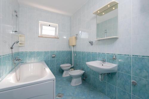 普特尼科维奇Apartments by the sea Cove Pjestata, Peljesac - 12381的蓝色瓷砖浴室设有水槽和卫生间