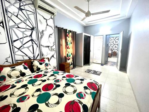 瓦加杜古Deluxe résidence的一间卧室配有一张带五颜六色棉被的床