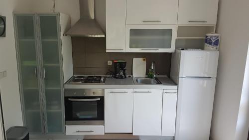 库希斯特Apartments by the sea Viganj, Peljesac - 12564的小厨房配有白色橱柜和冰箱。