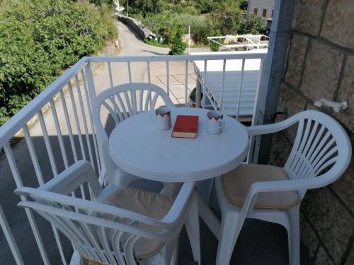 西利皮Apartments with a parking space Mocici, Dubrovnik - 12856的阳台上配有桌椅和书籍