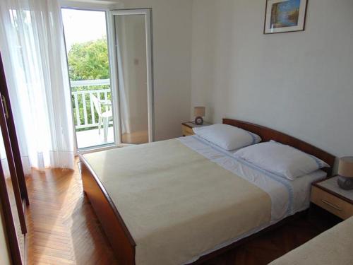 苏库拉伊Apartments and rooms by the sea Sucuraj, Hvar - 12887的一间卧室设有一张床和一个大窗户