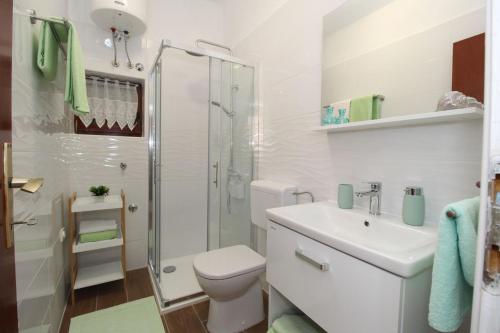 帕格Apartments and rooms with parking space Pag - 13060的白色的浴室设有卫生间和淋浴。