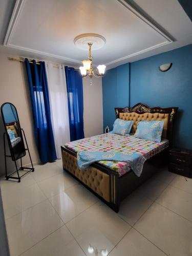 雅温得Lux Résidence的一间卧室配有一张蓝色墙壁和蓝色窗帘的床