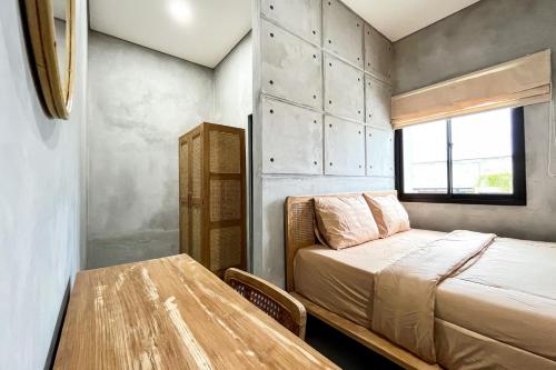 巨港Rattanhaus R Signature Mitra RedDoorz的一间小卧室,配有一张床和一张桌子