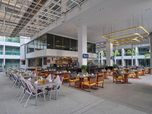芭东海滩The Kee Resort & Spa的大楼内带桌椅的餐厅