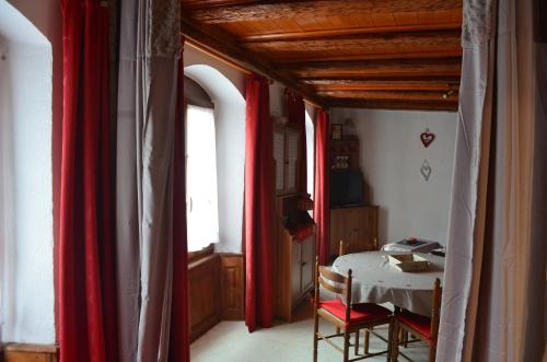 利克维复古一室公寓的一间设有红色窗帘、桌子和窗户的房间