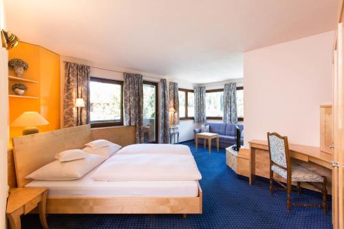圣安东阿尔贝格洛萨蔷薇高级酒店的酒店客房配有两张床和一张书桌