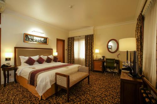 达卡皇家公园酒店的酒店客房设有一张大床和一张书桌。