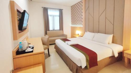 梭罗Al Azhar Azhima Hotel Resort and Convention的酒店客房带一张大床和一把椅子