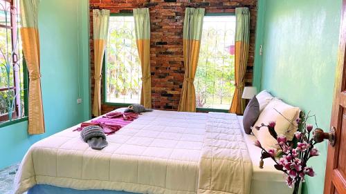 甲米镇Swiss Chalet Garden, Pool Resort的一间带一张大床的卧室,位于带窗户的房间内