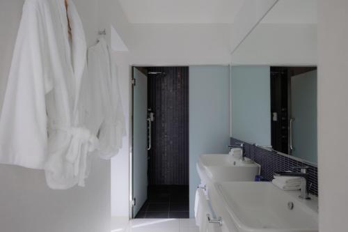 恩纳Homm Stay Yumiha Okinawa by Banyan Tree Group的白色的浴室设有3个水槽和镜子