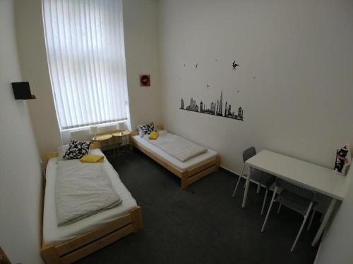 布尔诺ApartHostel Brno的客房设有两张床、一张桌子和一张书桌。