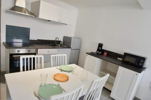 贝尔热拉克T2 Grand Espace calme et confort的厨房配有白色的桌子和白色的椅子