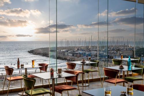特拉维夫特拉维夫海滩皇冠假日酒店的一间带桌椅的海景餐厅