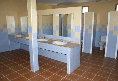 Navas de EstenaKampaoh Cabañeros的一间带三个盥洗盆和卫生间的公共浴室