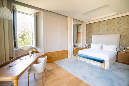 圣艾米隆Château de Ferrand的酒店客房配有一张床、一张书桌和一张书桌。