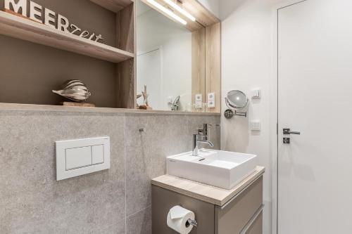 韦斯特兰NEU! Exklusives Apartment Turmkoje im Herzen Westerlands的一间带水槽和镜子的浴室