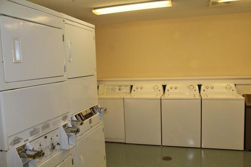 北锡拉丘兹锡拉丘兹机场烛木套房酒店的一间配备有白色洗衣机和烘干机的房间