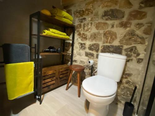 ValcabaTiñones cabaña pasiega的浴室配有白色卫生间和石墙。