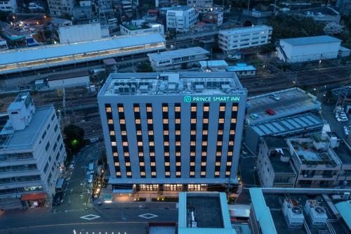 热海熱海王子智能酒店(Prince Smart Inn Atami)的建筑物的顶部景观,上面有标志