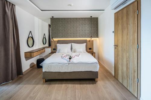 巴拉通雷勒H55的一间卧室配有一张铺有木地板的白色床单。