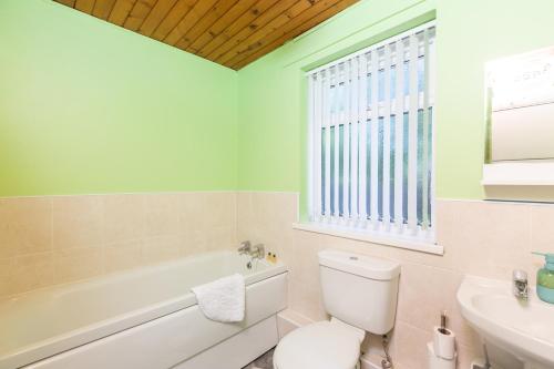 GorseinonSandfields House的浴室配有卫生间、浴缸和水槽。