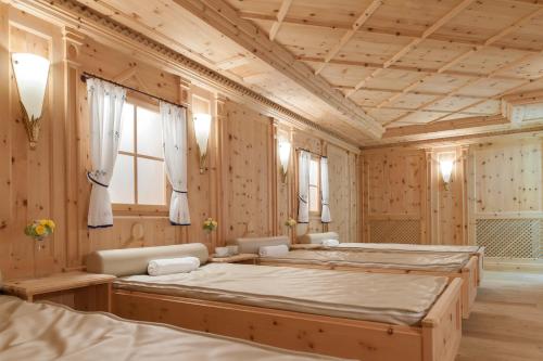 索尔登Regina Hotelsuites的一间卧室设有两张床和木墙