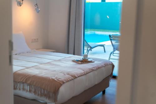 蓬塔德尔加达Populo's Place的一间卧室配有一张床,享有游泳池的景色
