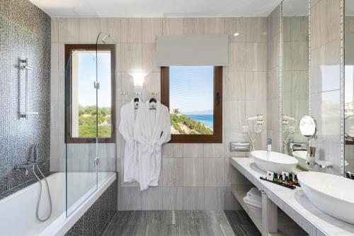 阿菲托斯Blue Bay Halkidiki的一间带两个盥洗盆、浴缸和窗户的浴室
