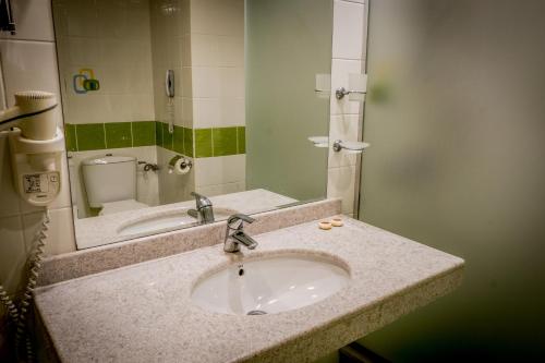 阿尔贝纳Hotel Gergana - Ultra All Inclusive的浴室的柜台设有水槽和镜子