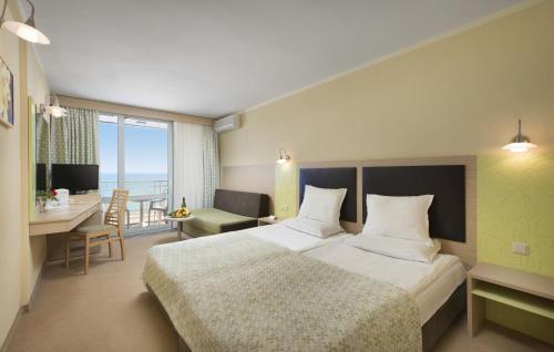 阿尔贝纳Hotel Gergana - Ultra All Inclusive的酒店客房设有一张大床和一张书桌。