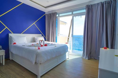 莫罗尼Golden Tulip Grande Comore Moroni Resort & Spa的卧室配有白色的床和蓝色的墙壁