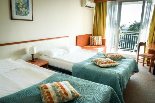 阿尔贝纳Hotel Laguna Garden的酒店客房设有两张床和一个阳台。