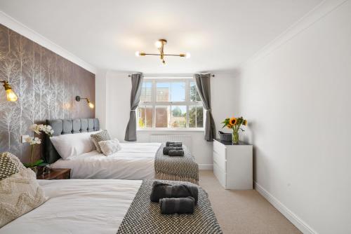 比斯特PRIME 3 BED HOUSE to BICESTER OUTLET for 8 People by Platinum Key Properties的一间卧室设有两张床和窗户。