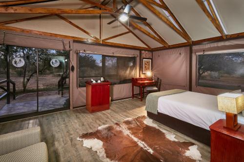 哈博罗内Manong Game Lodge的帐篷内一间卧室,配有一张床