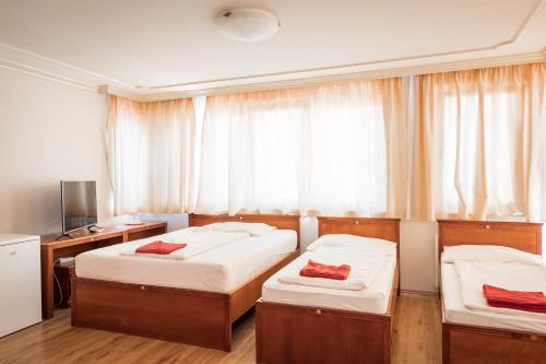 包姚Kaiser Residence的一间卧室设有两张床、一张桌子和一个窗口。