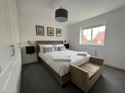 南安普敦Spacious & Stylish 4-Bed House with Hot Tub in Prime Location的卧室配有床、椅子和窗户。