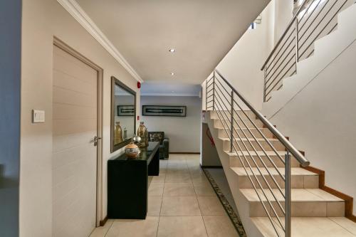 哈博罗内Regent Kgale Lodge的走廊上设有楼梯和镜子