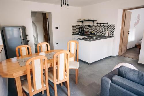 LjubnoŠtekner house Apartma的厨房以及带木桌和椅子的用餐室。