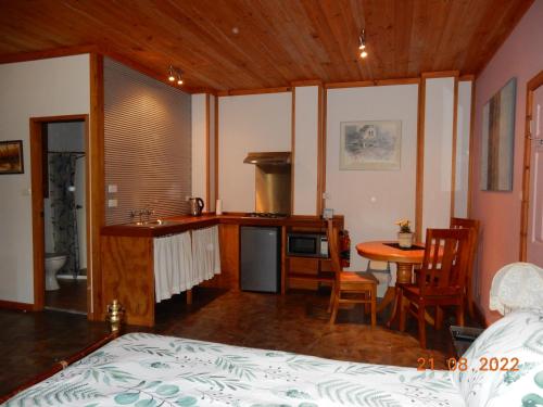 TomerongSelf-contained Cabin 10 min to Huskisson的一间卧室配有一张床,厨房配有桌子