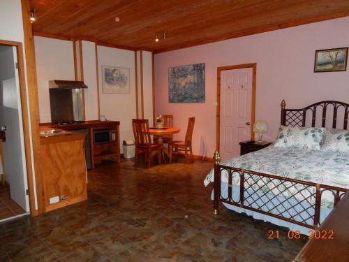 TomerongSelf-contained Cabin 10 min to Huskisson的卧室配有一张床和一张桌子及椅子