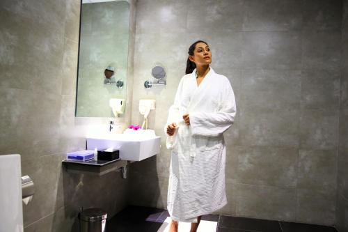 科伦坡科伦坡依丽安贝斯特韦斯特酒店的站在带水槽的浴室中的女人