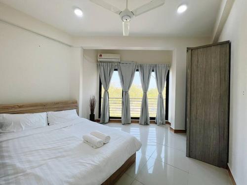 胡鲁马累BODU ASHI MALDIVES - Central 3 Bedroom Apartment的卧室配有白色的床和2条毛巾