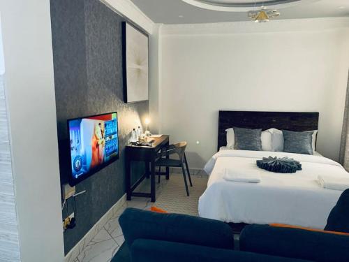 纳纽基Arabel Studio Apartment的一间卧室配有一张床、一张书桌和一台电视。