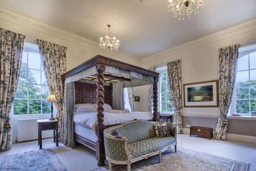 哈特尔普尔The Castle By Group Retreats的一间卧室配有一张天蓬床和一把椅子