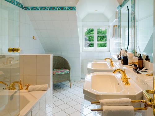 奥登塔尔Romantikhotel Altenberger Hof的白色的浴室设有2个盥洗盆和1个浴缸。