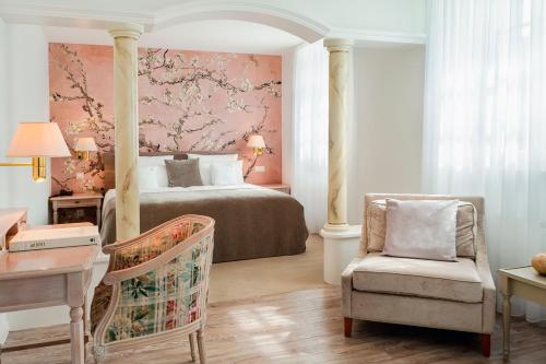 奥登塔尔Romantikhotel Altenberger Hof的一间卧室配有一张床、一把椅子和一张书桌