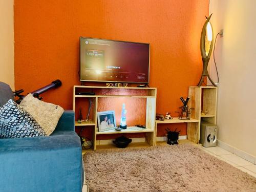 伦索伊斯Vila das Estrelas - Guesthouse的客厅配有蓝色的沙发和平面电视。
