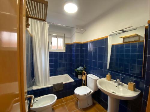马塔拉斯卡尼亚斯Villa Fumarel的蓝色瓷砖浴室设有卫生间和水槽